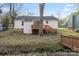 Spacious backyard with deck, wooden staircase, and mature trees, ready for outdoor enjoyment at 8220 Terra Linda Ln, Charlotte, NC 28215