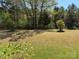 Large backyard featuring mature trees offering shade and a beautiful natural setting at 9895 Travertine Trl, Davidson, NC 28036