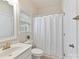 Bright bathroom featuring a shower with a white shower curtain and a window at 9895 Travertine Trl, Davidson, NC 28036