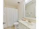 Bright bathroom with a shower-tub combo, large mirror and white fixtures at 9895 Travertine Trl, Davidson, NC 28036