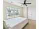 Comfortable bedroom featuring a green bed under a ceiling fan, with natural light from a large window at 9895 Travertine Trl, Davidson, NC 28036