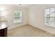 Empty bedroom with two windows, neutral carpet and freshly painted walls at 9895 Travertine Trl, Davidson, NC 28036