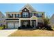 Charming two-story home with stone accents, manicured lawn, and a two-car garage at 9895 Travertine Trl, Davidson, NC 28036