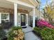 Inviting front porch with stone accents, lush landscaping, and a stylish front door at 9895 Travertine Trl, Davidson, NC 28036