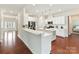 Bright white kitchen with stainless appliances, kitchen island, hardwood floors and breakfast bar seating at 9895 Travertine Trl, Davidson, NC 28036