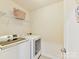 Laundry room featuring modern appliances and a wire shelf with wicker basket at 9895 Travertine Trl, Davidson, NC 28036