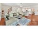 Open-concept living room featuring hardwood floors, staircase and flows into kitchen with a breakfast bar at 9895 Travertine Trl, Davidson, NC 28036