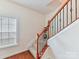 Staircase features stained hardwood steps and decorative wrought iron railings at 9895 Travertine Trl, Davidson, NC 28036