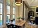 Bright dining area with large windows, a rustic wood table, and modern lighting fixtures at 1021 Mccollum Oaks Ln, Monroe, NC 28110
