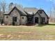 Charming home featuring stone and brick accents, complemented by a well-manicured lawn and mature trees at 1021 Mccollum Oaks Ln, Monroe, NC 28110