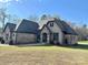 Spacious home with a blend of stone, brick, and siding, set on a lot with mature trees and lush landscaping at 1021 Mccollum Oaks Ln, Monroe, NC 28110