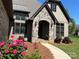 Charming front entrance with stone archway, lovely landscaping and a welcoming walkway leading to the door at 1021 Mccollum Oaks Ln, Monroe, NC 28110