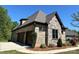 Garage exterior of this beautiful home boasts brick and stone accents and a well-maintained lawn at 1021 Mccollum Oaks Ln, Monroe, NC 28110