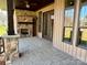Covered outdoor patio features stone fireplace, stained concrete, and french doors at 1021 Mccollum Oaks Ln, Monroe, NC 28110