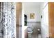 Small bathroom featuring neutral tile walls, decorative shower curtain, and commode with safety rails at 103 Perry St, Shelby, NC 28150