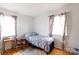 Bright bedroom with natural light, featuring hardwood floors and a single bed with colorful curtains at 103 Perry St, Shelby, NC 28150