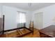 Empty bedroom showcasing hardwood floors, a closet and a chair, and a window with patterned curtains at 103 Perry St, Shelby, NC 28150