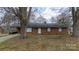 Ranch-style brick home with a driveway, manicured lawn, and mature trees in a quiet neighborhood at 103 Perry St, Shelby, NC 28150