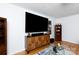 Living room with hardwood floors, a decorative cabinet, and a large flat-screen television at 103 Perry St, Shelby, NC 28150