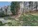 Spacious backyard featuring mature trees, a slope, and partial fencing, perfect for outdoor enjoyment at 10434 Henbane Ct, Charlotte, NC 28213