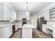 Bright kitchen features white cabinets, stainless steel appliances, gray backsplash, and a center island at 10434 Henbane Ct, Charlotte, NC 28213