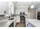 Bright kitchen features white cabinets, stainless steel appliances, gray backsplash, and a center island at 10434 Henbane Ct, Charlotte, NC 28213