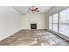 Spacious living room with fireplace, ceiling fan, and large windows at 10434 Henbane Ct, Charlotte, NC 28213