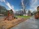 Spacious backyard featuring a playhouse, storage shed, mature tree and wood chip ground cover at 1115 Kelly Rd, Mount Holly, NC 28120