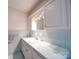Light blue bathroom featuring tiled walls and countertop with a sink and white cabinetry at 1115 Kelly Rd, Mount Holly, NC 28120