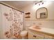 Bathroom with vintage tile, walk-in shower with floral curtain and a dark framed mirror at 1115 Kelly Rd, Mount Holly, NC 28120