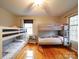 Bedroom features 2 bunk beds, wood floors, 2 windows, white walls, and a ceiling fan at 1115 Kelly Rd, Mount Holly, NC 28120