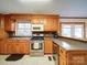 Cozy kitchen with stainless steel stove and microwave, wooden cabinets, and breakfast bar counter at 1115 Kelly Rd, Mount Holly, NC 28120