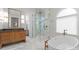 Bright bathroom with a glass enclosed shower, freestanding tub, wooden vanity, and herringbone tile flooring at 12014 James Jack Ln, Charlotte, NC 28277