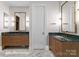 Modern bathroom featuring double vanities with green countertops, unique lighting fixtures, and herringbone tile floor at 12014 James Jack Ln, Charlotte, NC 28277