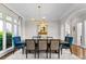 Bright dining room with large windows, modern chandelier, and stylish blue upholstered chairs at 12014 James Jack Ln, Charlotte, NC 28277