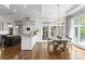 Bright kitchen with white cabinets, an island with dark wood accents, and a dining area with access to the patio at 12014 James Jack Ln, Charlotte, NC 28277