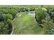 Picturesque view of the golf course featuring manicured greens, a pond, and mature trees at 12014 James Jack Ln, Charlotte, NC 28277