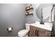 Half bath with gray walls, wood-look vanity, and a round mirror at 129 Doncaster Dr, Mooresville, NC 28115