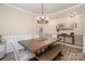 Dining room featuring wood floors, a modern chandelier, and a large wood table with a bench and chairs at 129 Doncaster Dr, Mooresville, NC 28115