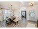 Bright dining room featuring wood floors, a modern chandelier, and large windows with sheer curtains at 129 Doncaster Dr, Mooresville, NC 28115