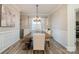 Elegant dining room featuring paneled walls, modern light fixture, and large wood table at 129 Doncaster Dr, Mooresville, NC 28115