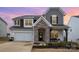Charming two-story home with a mix of siding and stone accents, with an attached two car garage and manicured lawn at 129 Doncaster Dr, Mooresville, NC 28115
