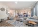 Open concept living room with an area rug, gray sofas, and natural light at 129 Doncaster Dr, Mooresville, NC 28115