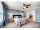 Bright bedroom featuring soft blue walls, ceiling fan, ensuite bathroom at 13240 Carolina Wren Ct, Charlotte, NC 28278