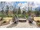 Cozy backyard features a stone fire pit and Adirondack chairs on a paver patio for outdoor enjoyment at 13240 Carolina Wren Ct, Charlotte, NC 28278