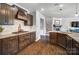 Well-equipped kitchen with dark wood cabinets, stainless appliances, gas range, and granite countertops with wood floors at 13240 Carolina Wren Ct, Charlotte, NC 28278