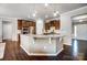 Open kitchen featuring a center island with granite countertops and stainless steel appliances with dark wood floors at 13240 Carolina Wren Ct, Charlotte, NC 28278