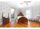 Cozy bedroom with hardwood floors, a rocking chair, and charming vintage wallpaper at 143 Reid St, Rock Hill, SC 29730