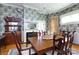 Spacious dining room with a large wooden table, a classic fireplace, and decorative wallpaper for elegant dining at 143 Reid St, Rock Hill, SC 29730