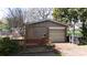 Exterior view of a detached garage with a brick facade and a roll-up door, surrounded by trees at 143 Reid St, Rock Hill, SC 29730